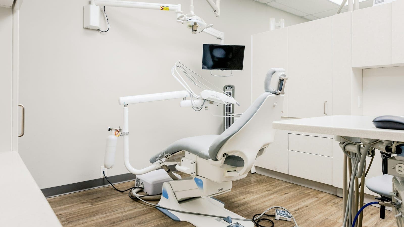 Salle de soins d'un cabinet dentaire, fauteuil et écrans, sans patient