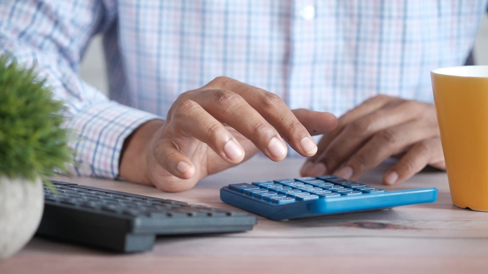 Justificatifs et notes de frais posés sur un bureau à côté d'une calculatrice