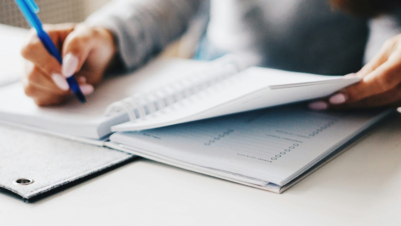 Praticienne libérale prenant des notes sur un carnet à son bureau
