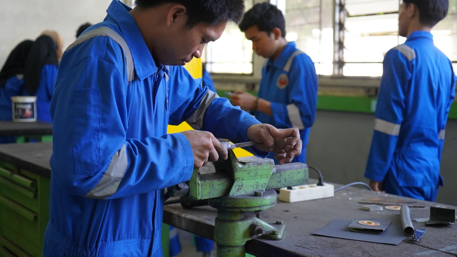 Apprentis en combinaison de travail à l'établi dans un atelier de formation