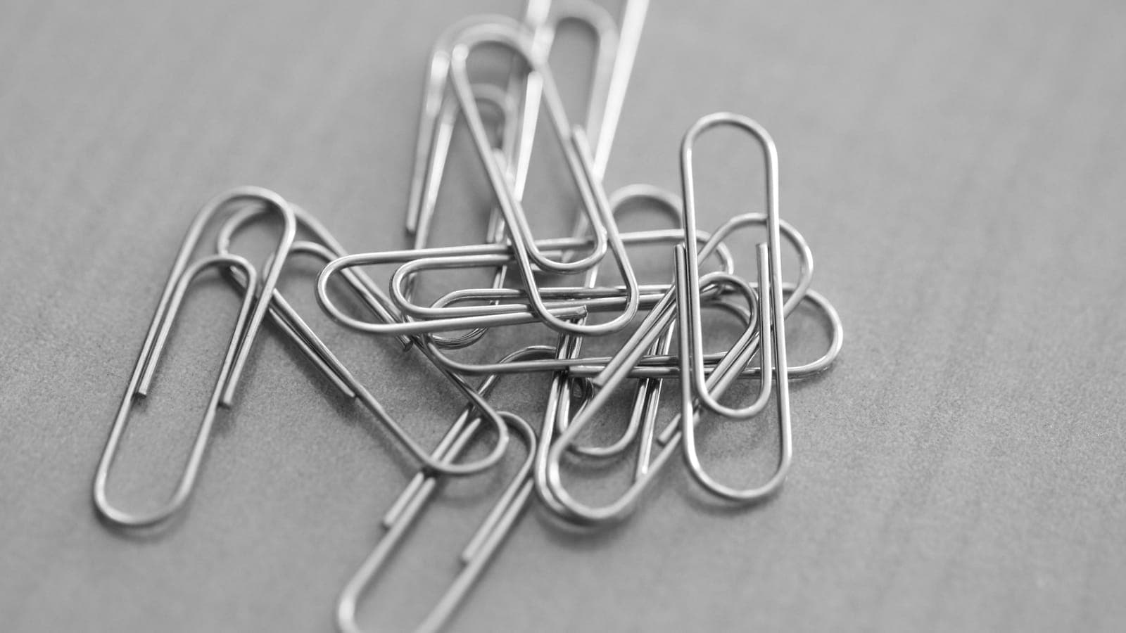 Trombones métalliques entremêlés sur une surface grise