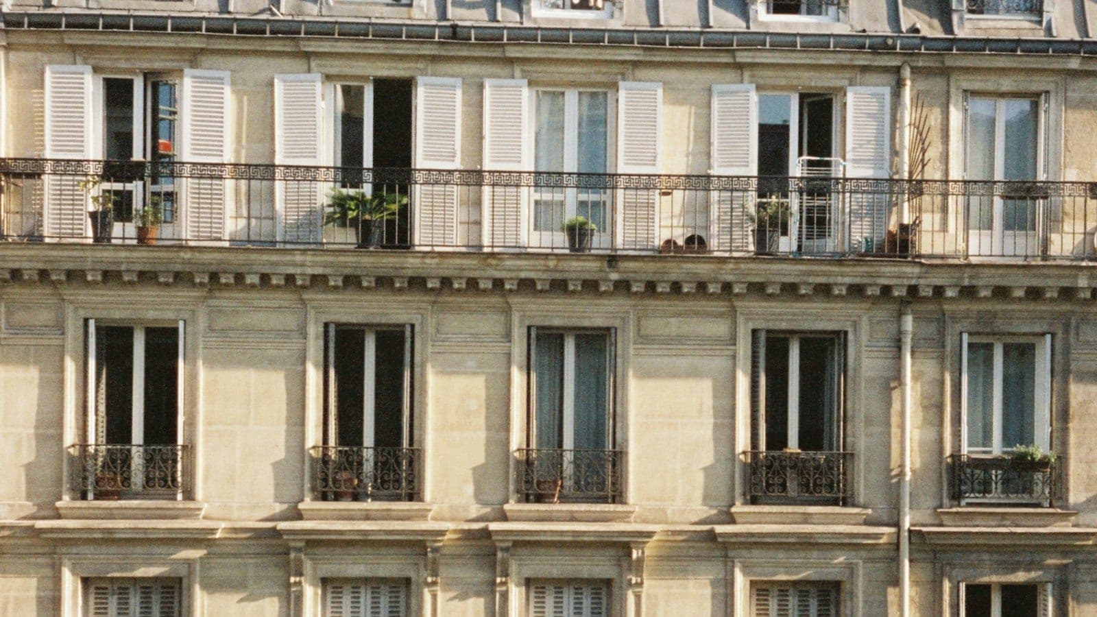 Façade d'immeuble parisien en pierre avec balcons en fer forgé