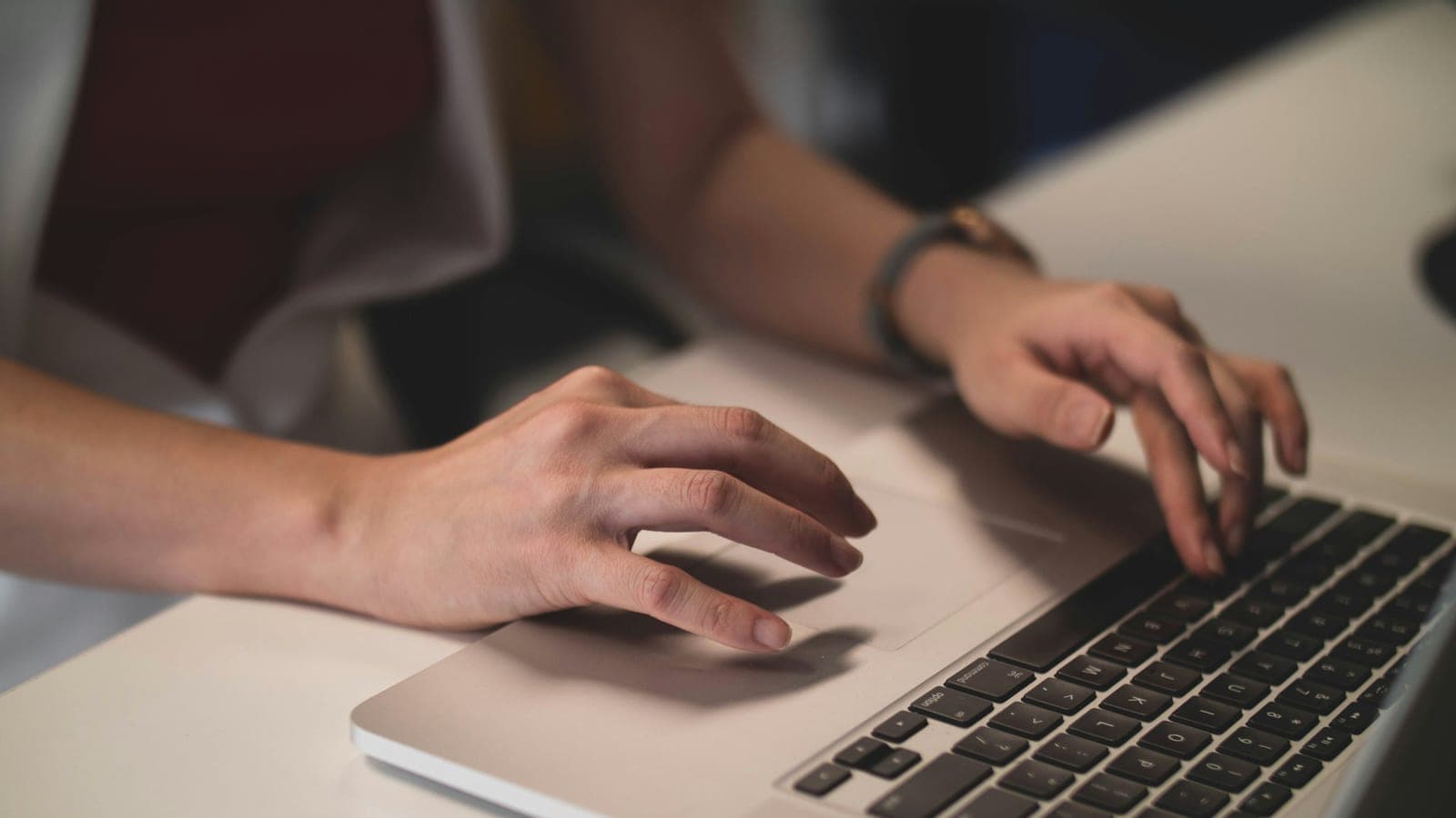 Gros plan de deux mains posées sur le clavier d'un ordinateur portable