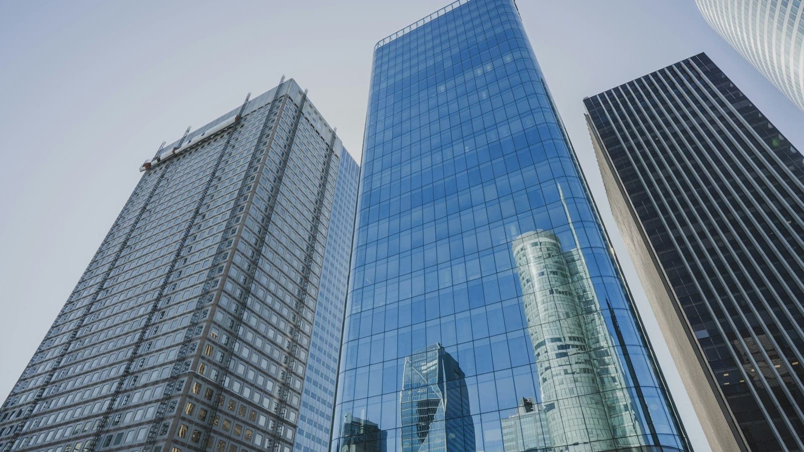 Tours de bureaux aux façades de verre vues en contre-plongée, sous un ciel clair