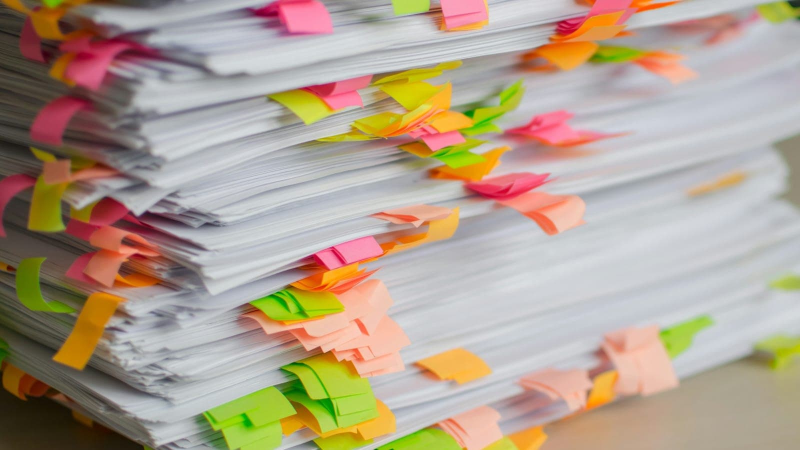 Pile de documents papier marqués de nombreux onglets de couleur