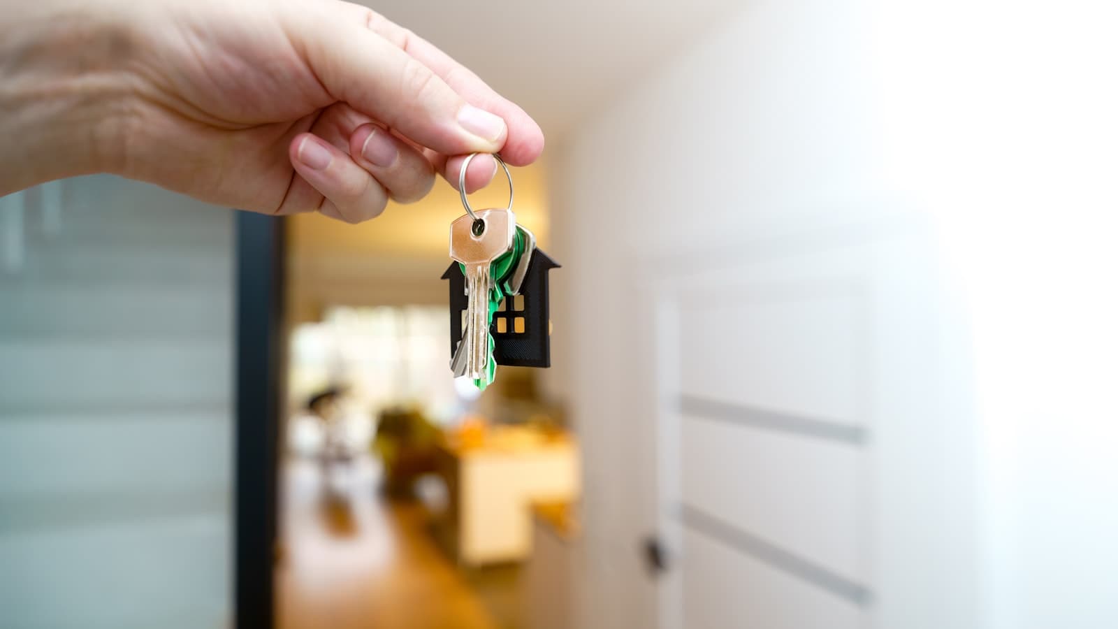 Remise d'un trousseau de clés devant l'entrée d'un logement